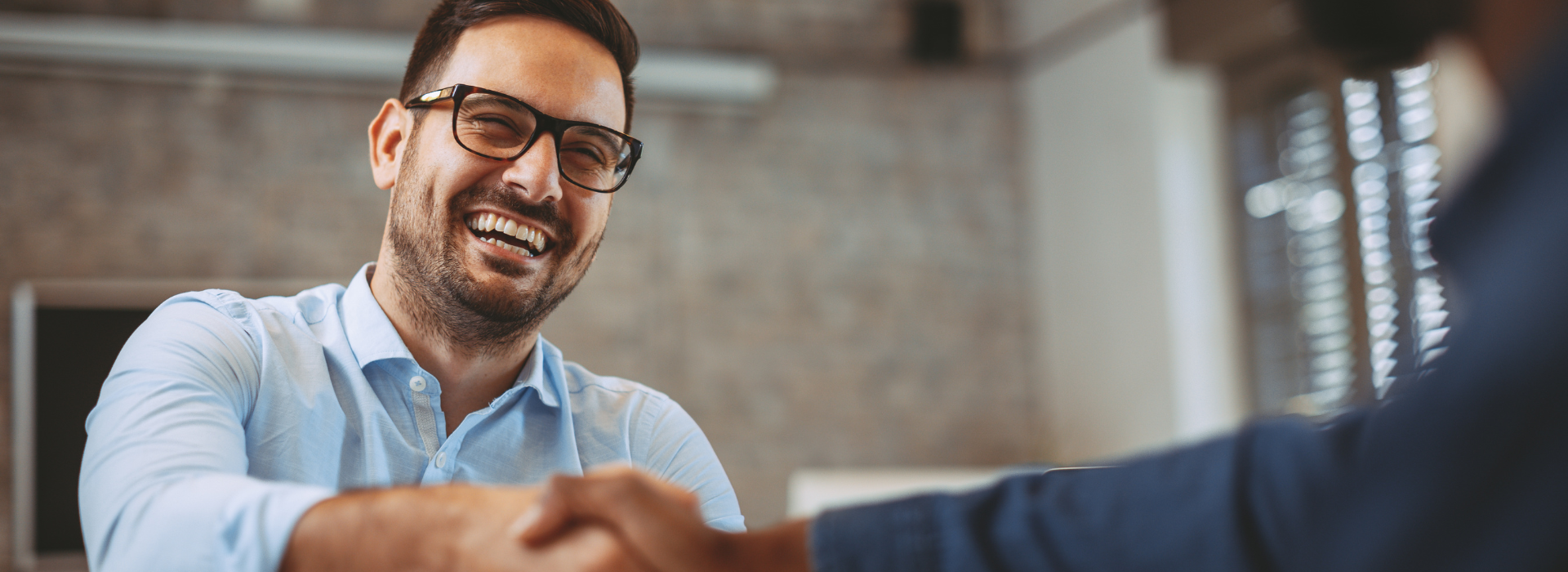 Education consultant shaking hands with Atava representative during partner discussion