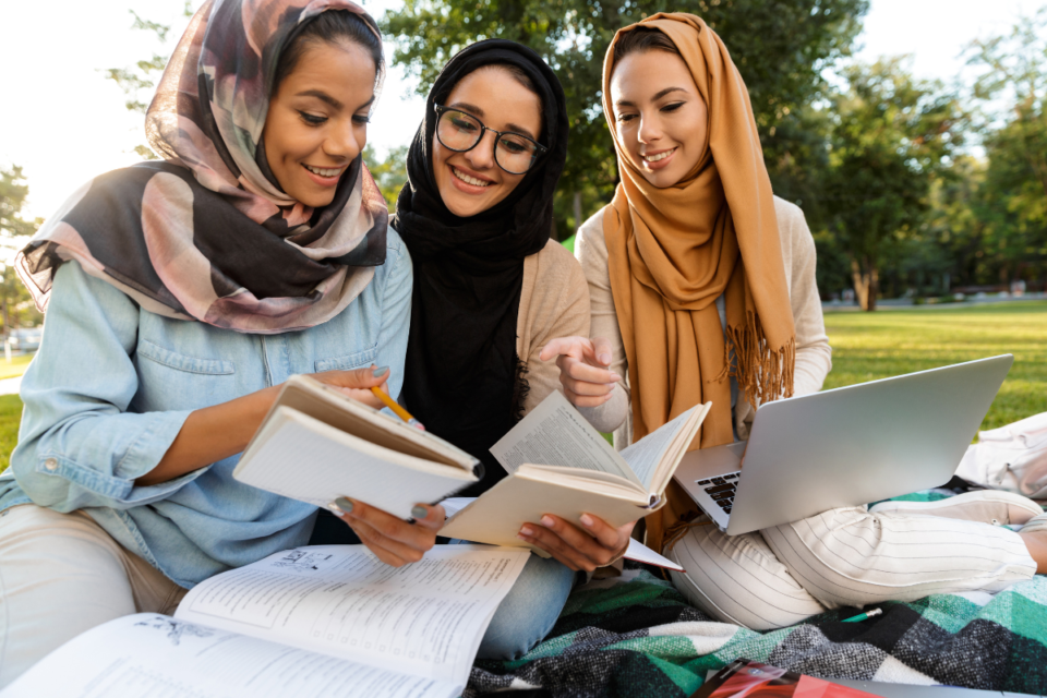 Female students from the United Arab Emirates studying together outdoors in the UK